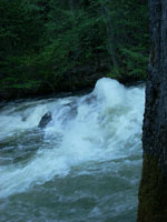 river pounding against a large boulder